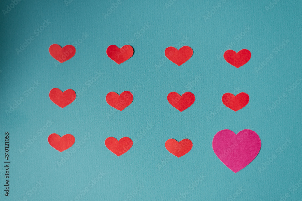 Red hearts and one big pink heart on a blue background. Valentine's day card