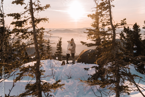 Couple in winter in the mountains at sunset photo