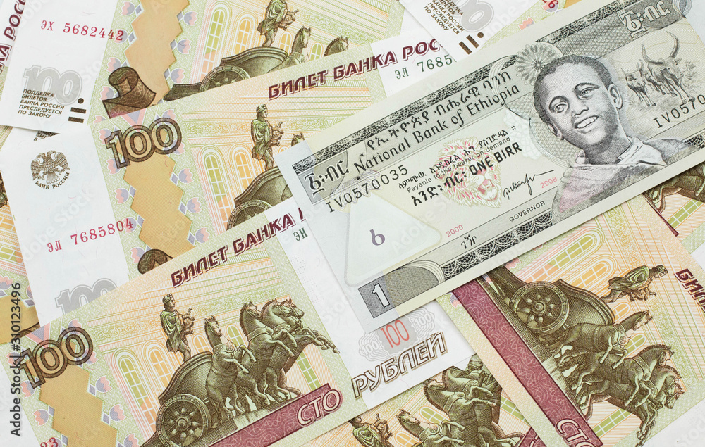 A close up image of a one Ethiopian birr bank note on a background of Russian one hundred ruble bank notes A close up image of a one Ethiopian birr bank note on a background of Russian one hundred ruble bank notes