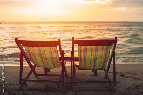 two blank beach bed chair set on the beach with sun twilight sky background. © Quality Stock Arts