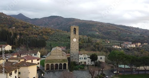 Orbit Aerial view of Ancient roman entire stone church of Peter and Paul Saints at Cascia, Reggello containing famous italian Masaccio paintings. Tuscany, Italy. Cloudy winter day at sunset photo