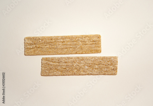 Two thin dry bread on a beige background.