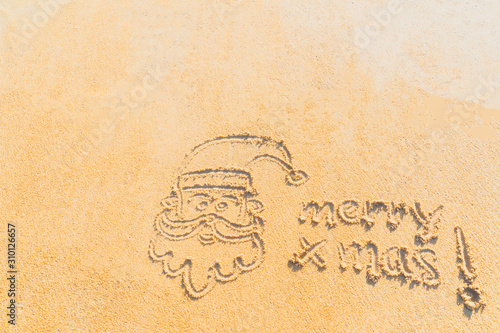 Concept Christmas on the beach Tropical design made in Phuket, Thailand Write the alphabet on the sand background Taken from real locations.