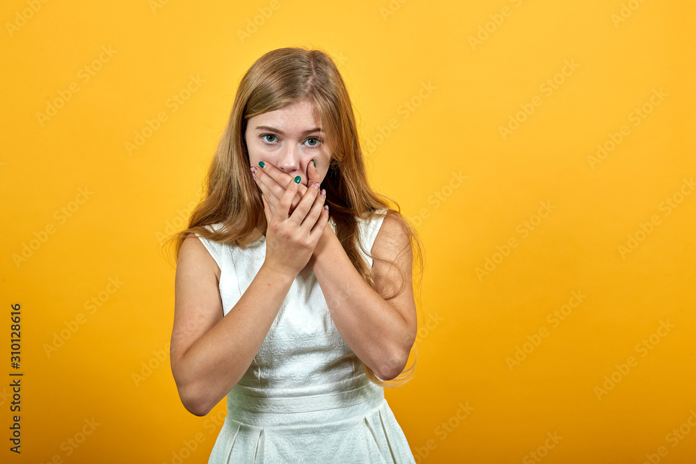 Scared young woman in fashion white shirt over isolated orange background, covering mouth with hands, looking frightened. Lifestyle concept Scared young woman in fashion white shirt over isolated orange background, covering mouth with hands, looking frightened. Lifestyle concept