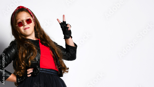 Young positive plus size girl in rock style clothing, red boots and square glasses standing and showing peace sign with fingers