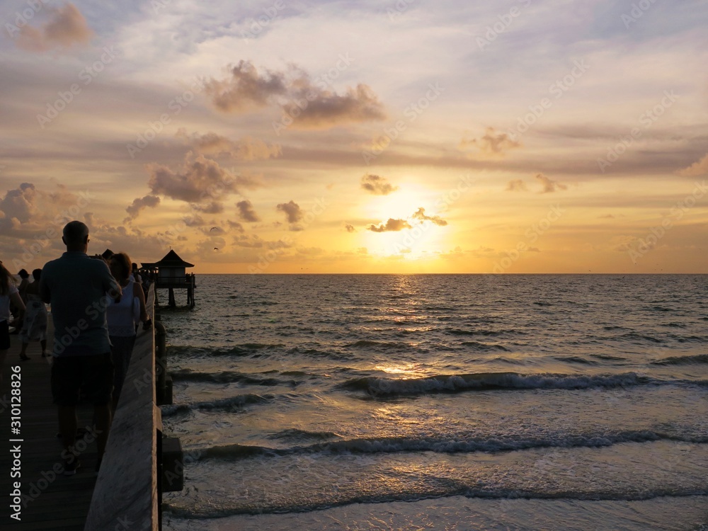 Fototapeta premium Sonnenuntergang am Strand und Pier von Naples, Florida