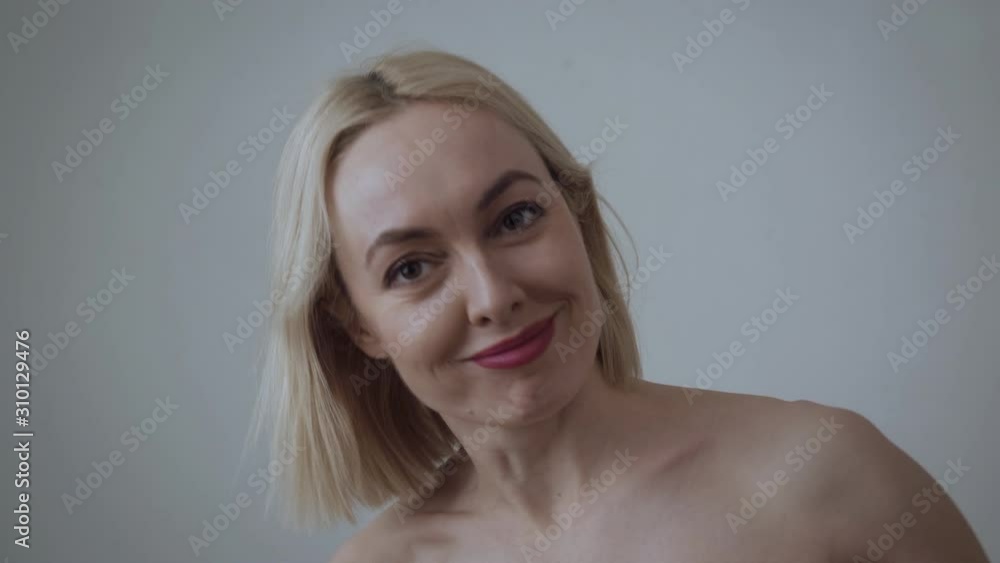Beautiful adult woman smiling, shows and kisses biceps. Beautiful adult woman smiling, shows and kisses biceps.