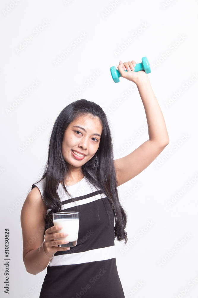 Healthy Asian woman drinking a glass of milk and dumbbell Healthy Asian woman drinking a glass of milk and dumbbell