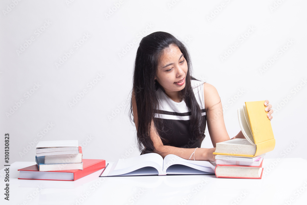 Young Asian woman read a book with books on table Young Asian woman read a book with books on table