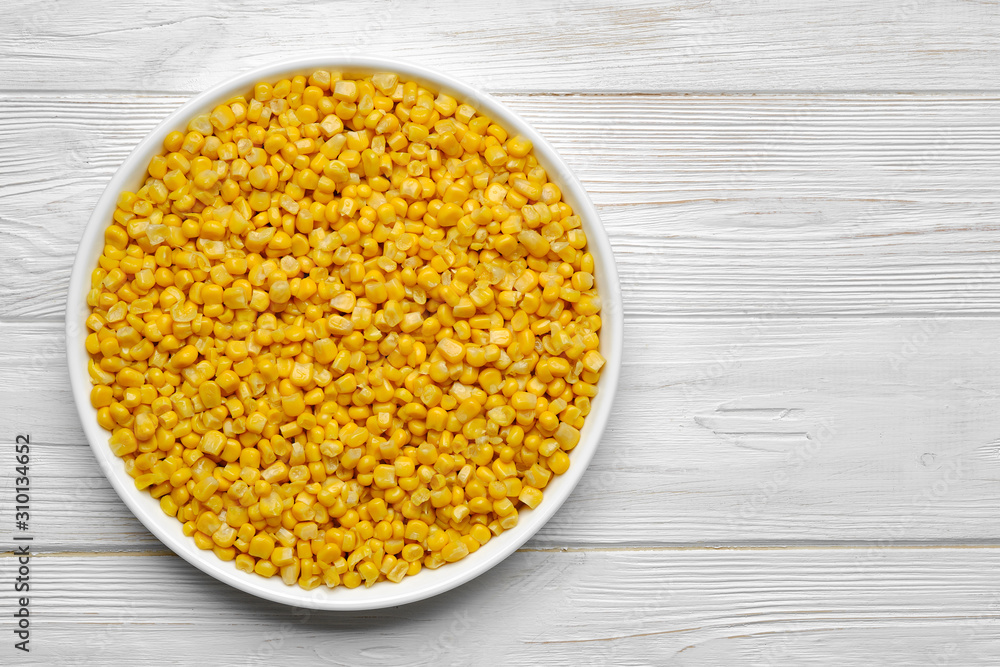 canned corn in white plate top view. white wooden background canned corn in white plate top view. white wooden background