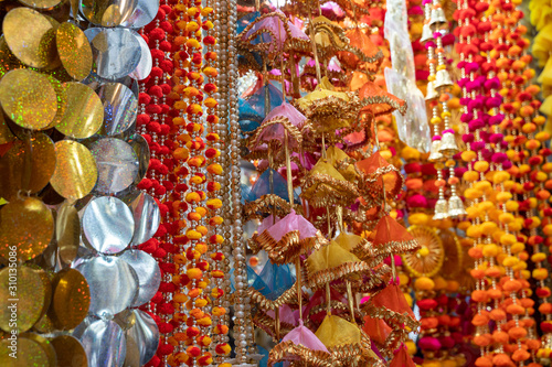 Colorful hanging decorations on display for sale in Chandi Chowk Old Delhi. These flowers, beads and bells designs are popular in weddings, festivals and events.