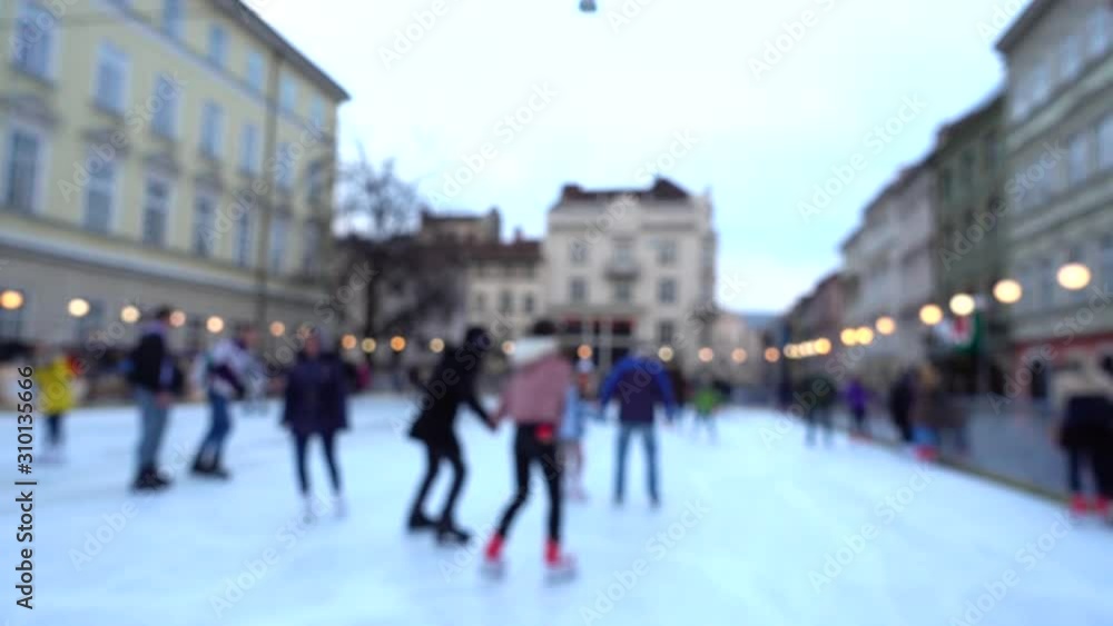 Unknown people skate in the square of the city. Out of focus. Unknown people skate in the square of the city. Out of focus.