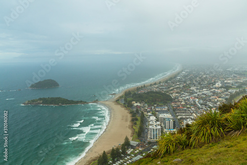ニュージーランド　タウンランガ湾の半島にあるマウント・マウンガヌイのマウアオの丘の麓から見えるビーチと街並み © pespiero