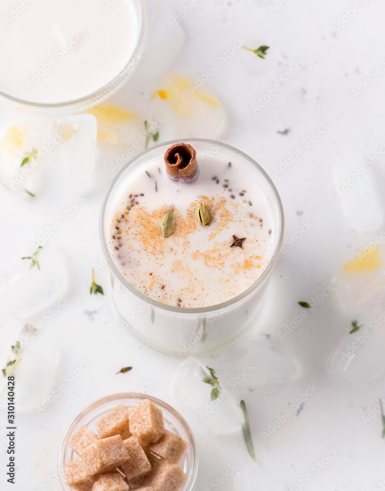 Milkshake with spices on a white plate next to cane sugar Milkshake with spices on a white plate next to cane sugar
