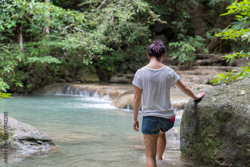 young cute hipster girl travelling at beautiful Erawan waterfall mountains  green forest hiking views at Kanchanaburi  Thailand. guiding  idea for female backpacker woman women backpacking