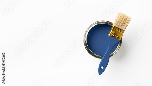 Can of Classic blue paint and brush on white background. Trendy color concept. Top view.