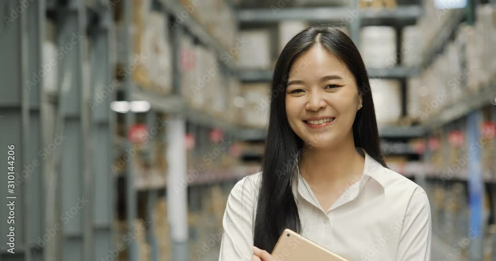 Beautiful business woman using tablet for choose product in a large industrial room of a furniture warehouse. Beautiful business woman using tablet for choose product in a large industrial room of a furniture warehouse.