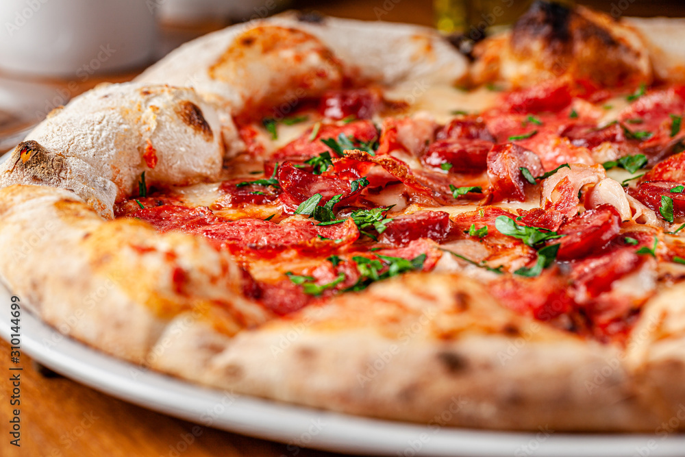 Italian food concept. Thin pizza with thick sides on a white plate. background image. copy space Italian food concept. Thin pizza with thick sides on a white plate. background image. copy space