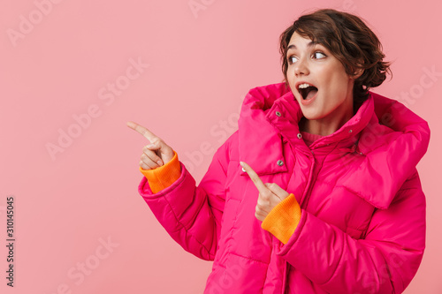 Portrait of beautiful excited woman looking and pointing fingers aside