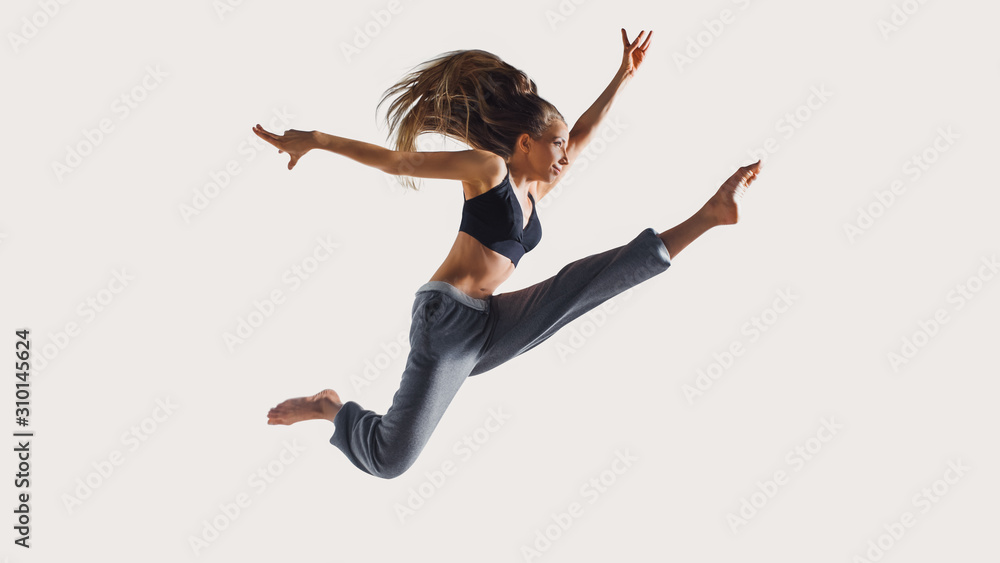 Never stop run. Full length of young athlete woman with perfect body in sports clothing jumping