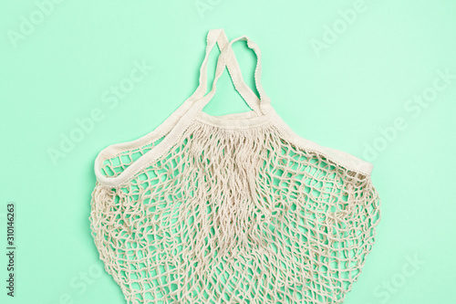 Top view of beige color reusable shopping bag on mint background