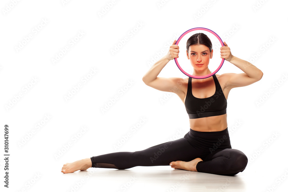 Young fit yoga woman with a fitness wheel. Isolated on white background. Young fit yoga woman with a fitness wheel. Isolated on white background.