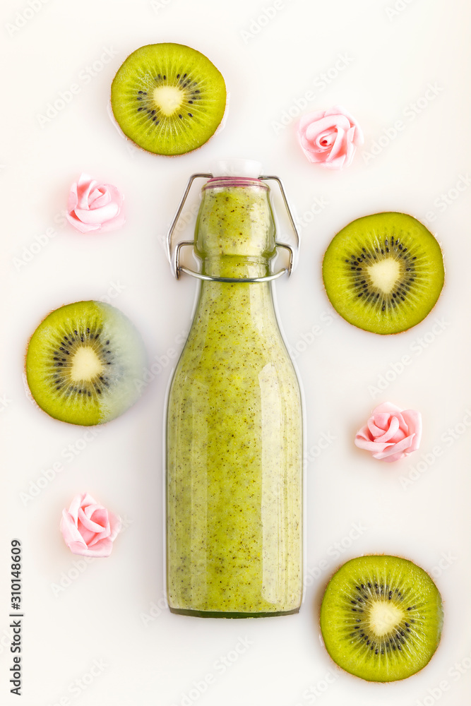 Bottled kiwi smoothie with slices of fresh kiwi and little flowers in a  milk bath. Vegetarian, organic, bio and detox drink. Concepts of nutrition,  dietetics, health care, wellness and lifestyle Stock Photo |