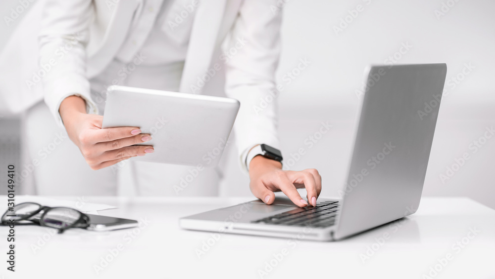 Cropped image of busy girl using tablet and computer