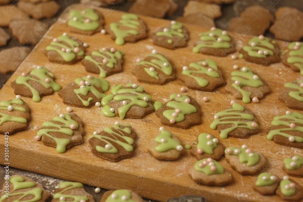 Christmas homemade gingerbread cookie sprinkled with green sugar on a wooden board