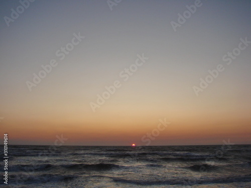 Incredible natural picture of a colorful sky over the stormy blue infinity of the Azov Sea at dawn.