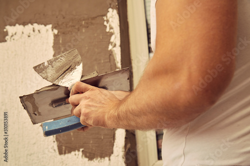 Construction worker plaster a wall.