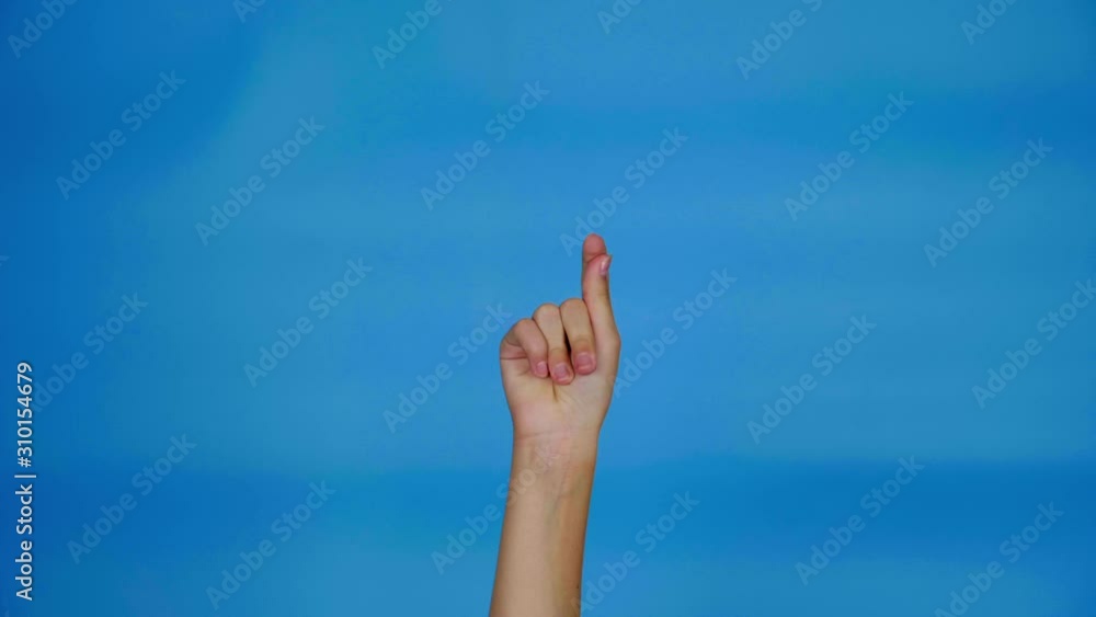 Female hand snaps her fingers on blue background with copy space. Hand of teenage girl. 4k slowmotion footage Female hand snaps her fingers on blue background with copy space. Hand of teenage girl. 4k slowmotion footage
