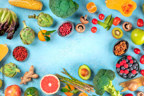 Fototapeta Naklejka Na Ścianę i Meble -  Vegan food. Healthy diet concept. Fruits, vegetables, pasta, nuts, legumes, mushrooms, shot from above on a blue background, forming a frame with a place for text. A flat lay composition