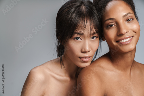 Portrait of two multinational women posing and looking at camera