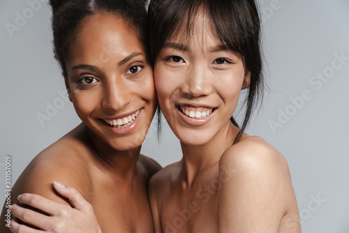 Portrait of two multinational half-naked women hugging and laughing