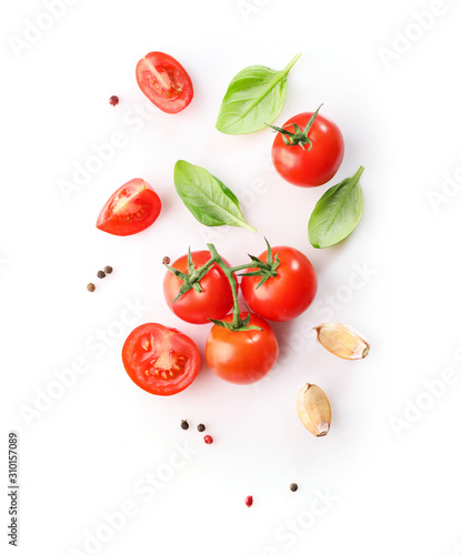Fotografia Ripe red cherry tomatos  and basil isolated on white background