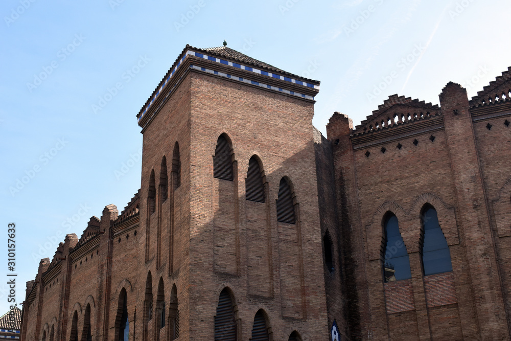 Square Tower & Ornate Features on Bare Brick Building 