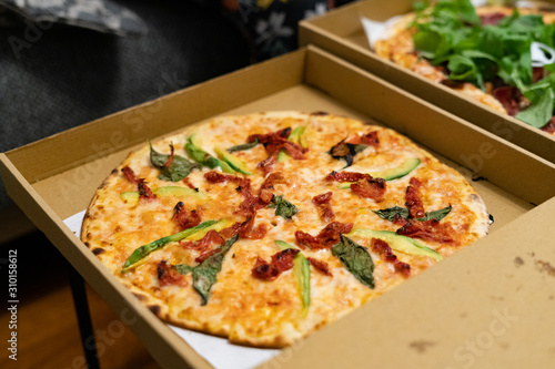 Take Away Pizza Box with Arugula, Rocket or Rucola Leaves and Avocado.