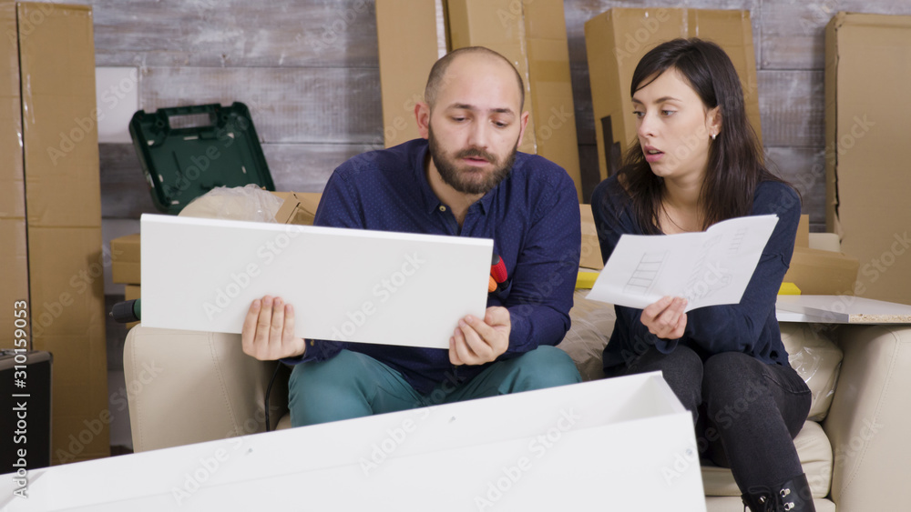 Girlfriend and boyfriend assembling furniture in their new apartment Girlfriend and boyfriend assembling furniture in their new apartment
