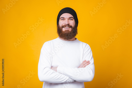 Portrait of smiling bearded hipster man with crossed arms looking at the camera