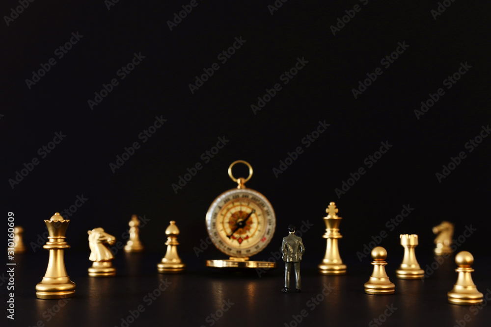 Image of chess game. Businessman looking at compass and pawns