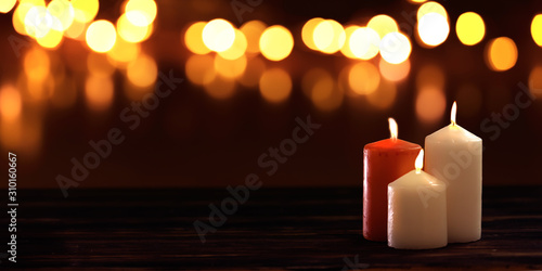 Christmas holiday burning candles on blurred background with bokeh lights
