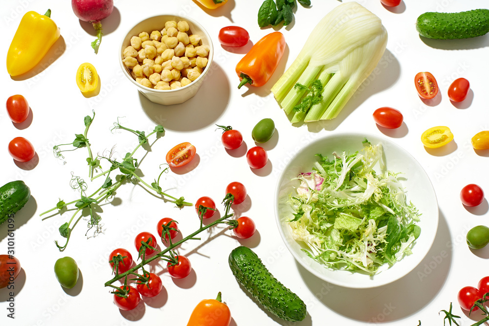 Healthy salad ingredients on white background in hard sun light with harsh shadows. Vegan meal. Pattern isolated Healthy salad ingredients on white background in hard sun light with harsh shadows. Vegan meal. Pattern isolated