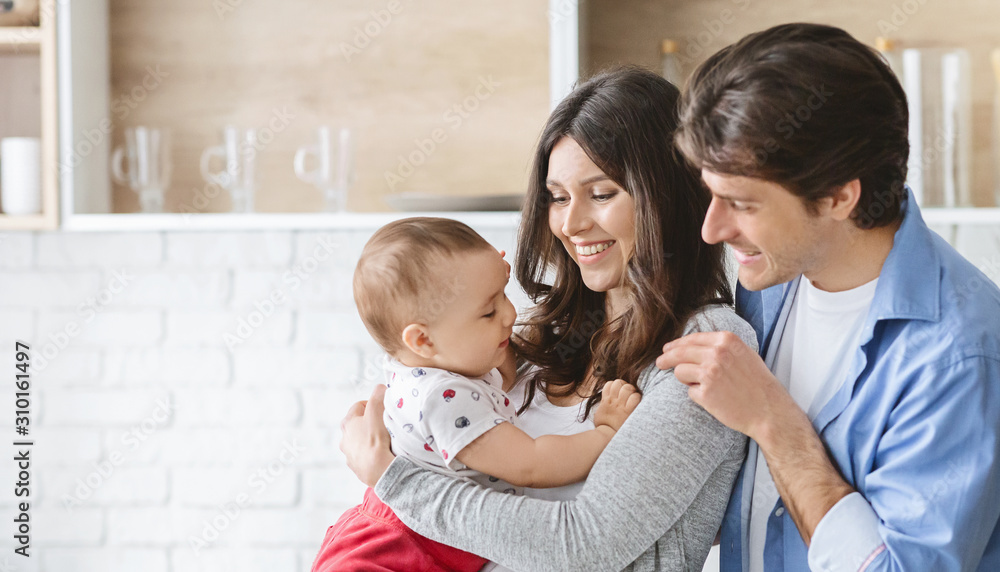 Happy parents with their adorable baby son in kitchen Happy parents with their adorable baby son in kitchen