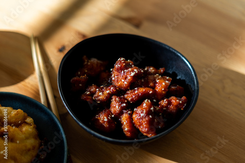 Asian Food Homemade Chinese General Tsos Chicken with Sesame Seeds served with Chopsticks. photo