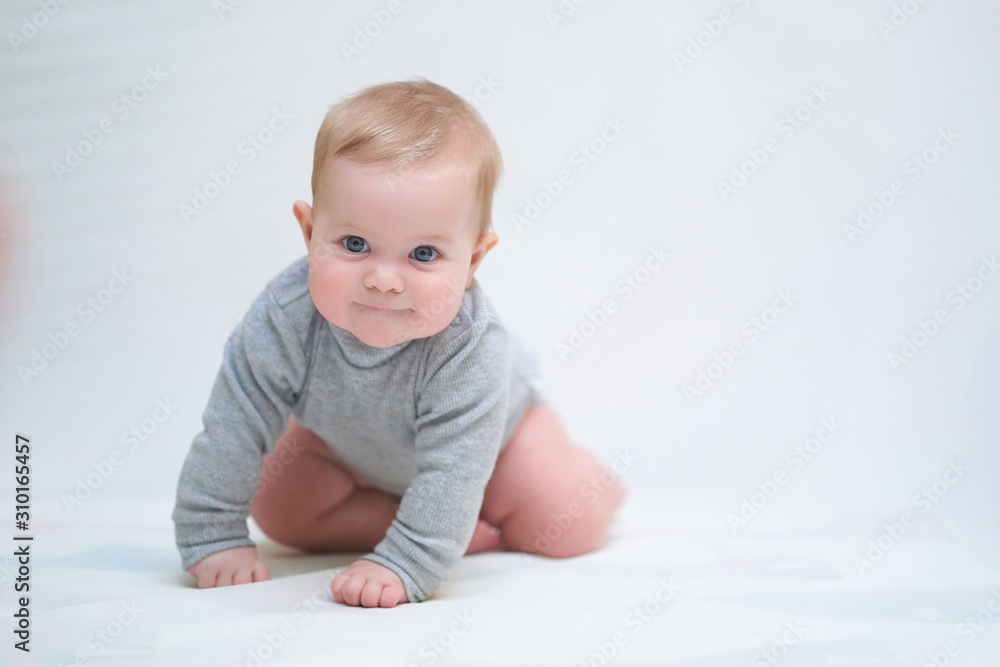 a six-month-old baby learns to crawl. emotional portrait of a child a six-month-old baby learns to crawl. emotional portrait of a child