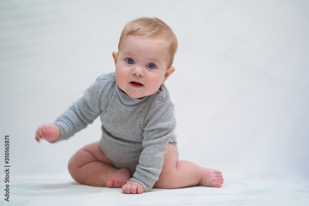 a six-month-old baby learns to crawl. emotional portrait of a child a six-month-old baby learns to crawl. emotional portrait of a child