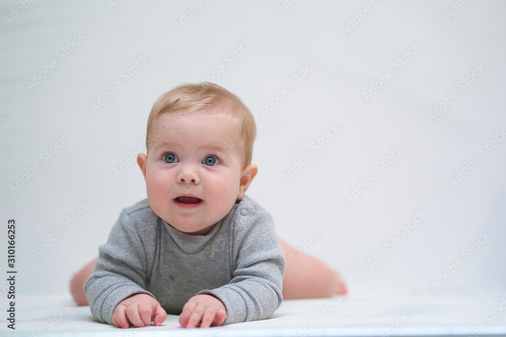 a six-month-old baby learns to crawl. emotional portrait of a child a six-month-old baby learns to crawl. emotional portrait of a child
