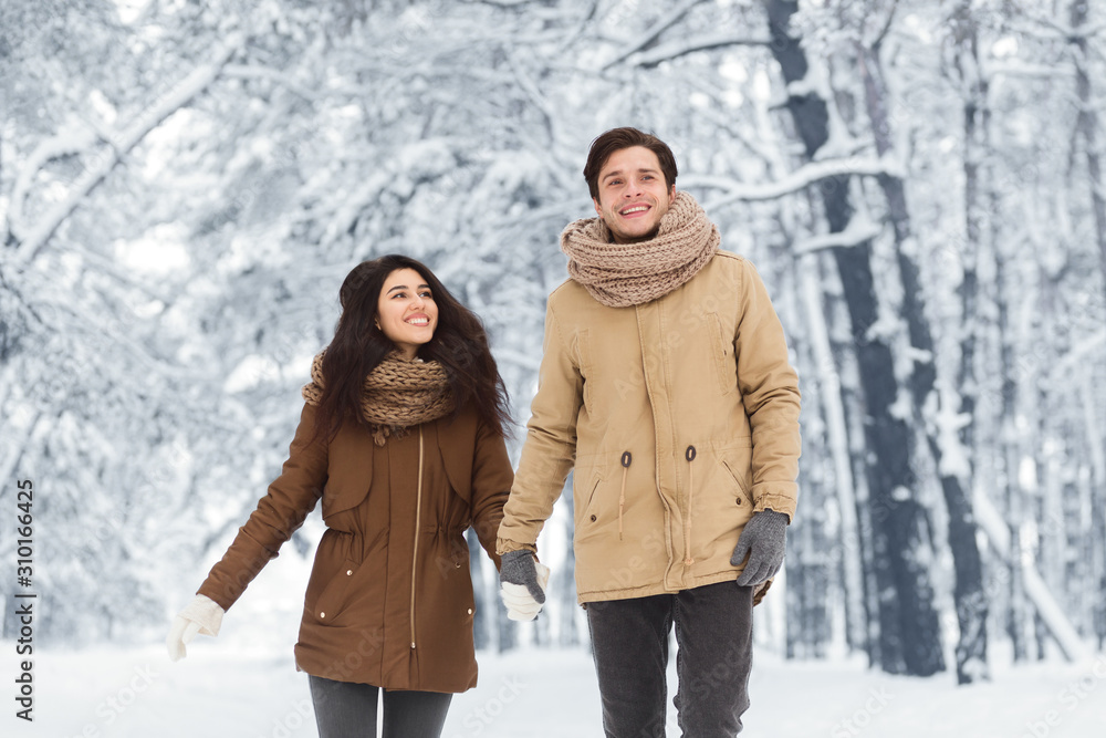 Smiling Couple Walking Holding Hands In Forest On Christmas Morning