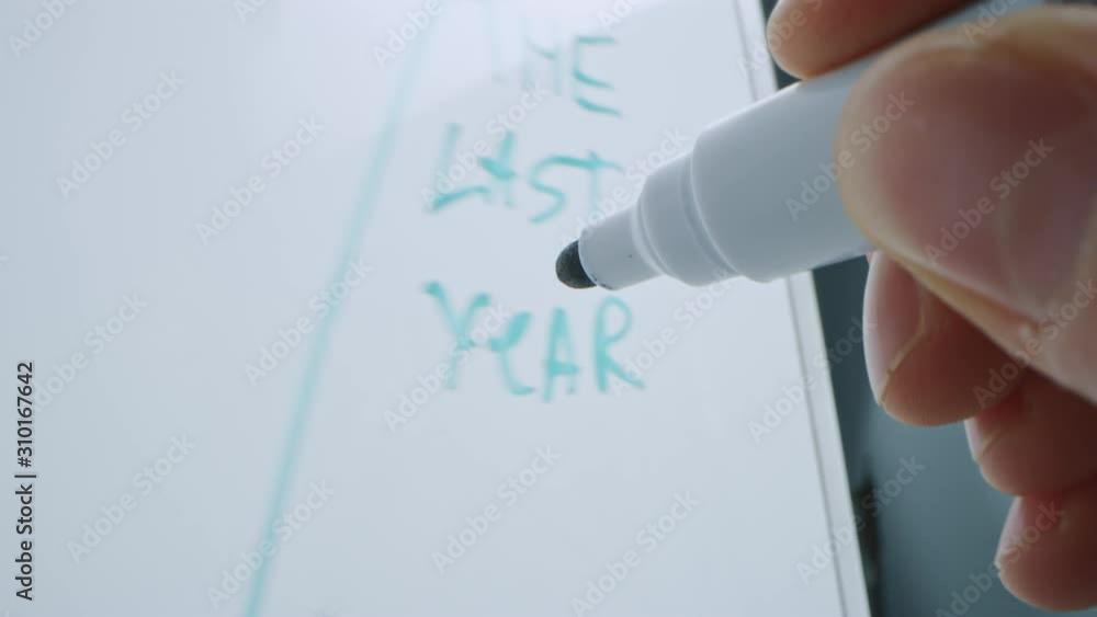 Macro Follow Shot of a Blue Marker Pen Being Held with a Hand. Person Drawing Graphs on a Whiteboard. Pencil is Connected to the Camera. Gripped Shot. Sketching with Fineliner.